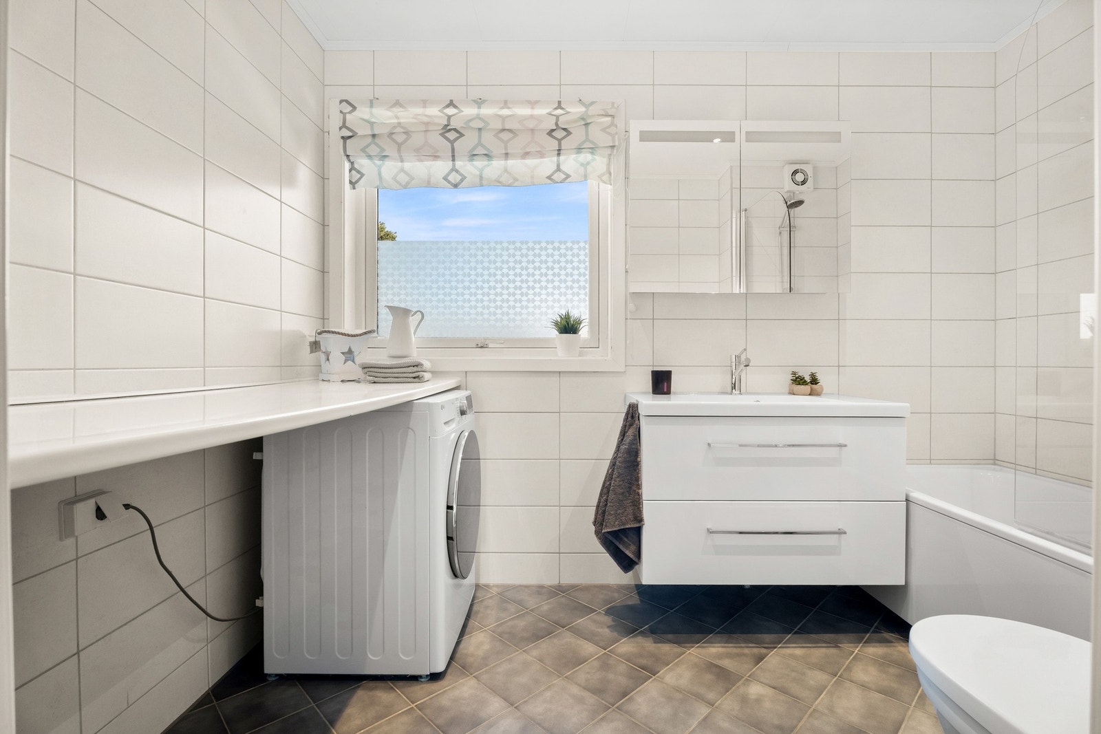 Opplegg og plass til vaskemaskin og tørketrommel med laminat benkeplate over. Galleribilde