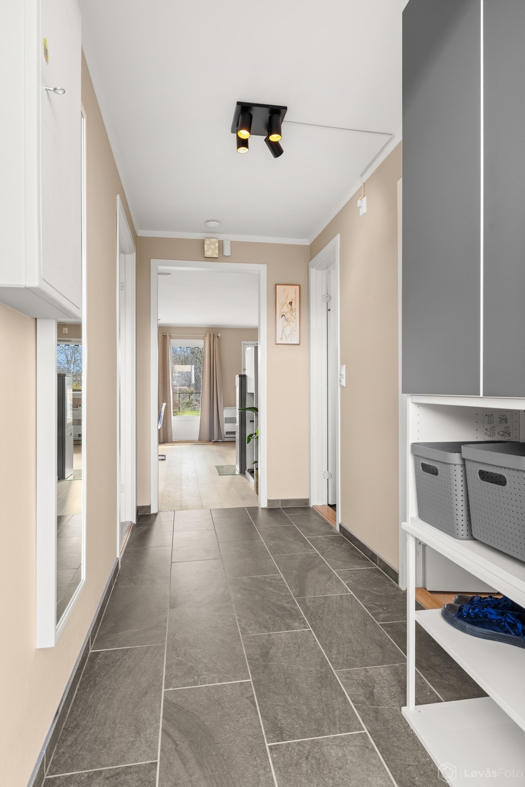 Entré med fliser og gulvvarme fornyet i 2024. Fra gangen er det en klar siktlinje gjennom leiligheten mot stuen og utgangen til terrassen, noe som gir en god romfølelse. Galleribilde