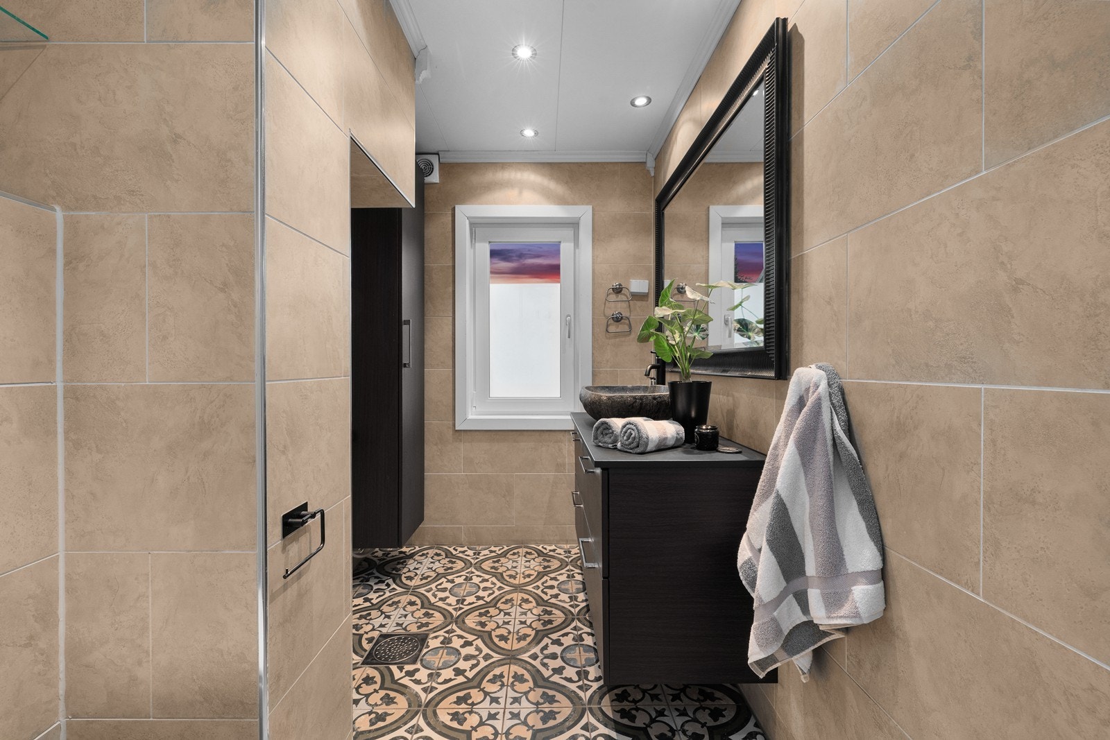Leiligheten har en praktisk planløsning med bad i begge etg. Oppe er badet innredet m/ mønstrede gulvfliser og store veggfliser i en dus jordtone. Varme er lagt i gulvet, og badet har downlights, åpent dusjhjørne og vegghengt toalett. Galleribilde