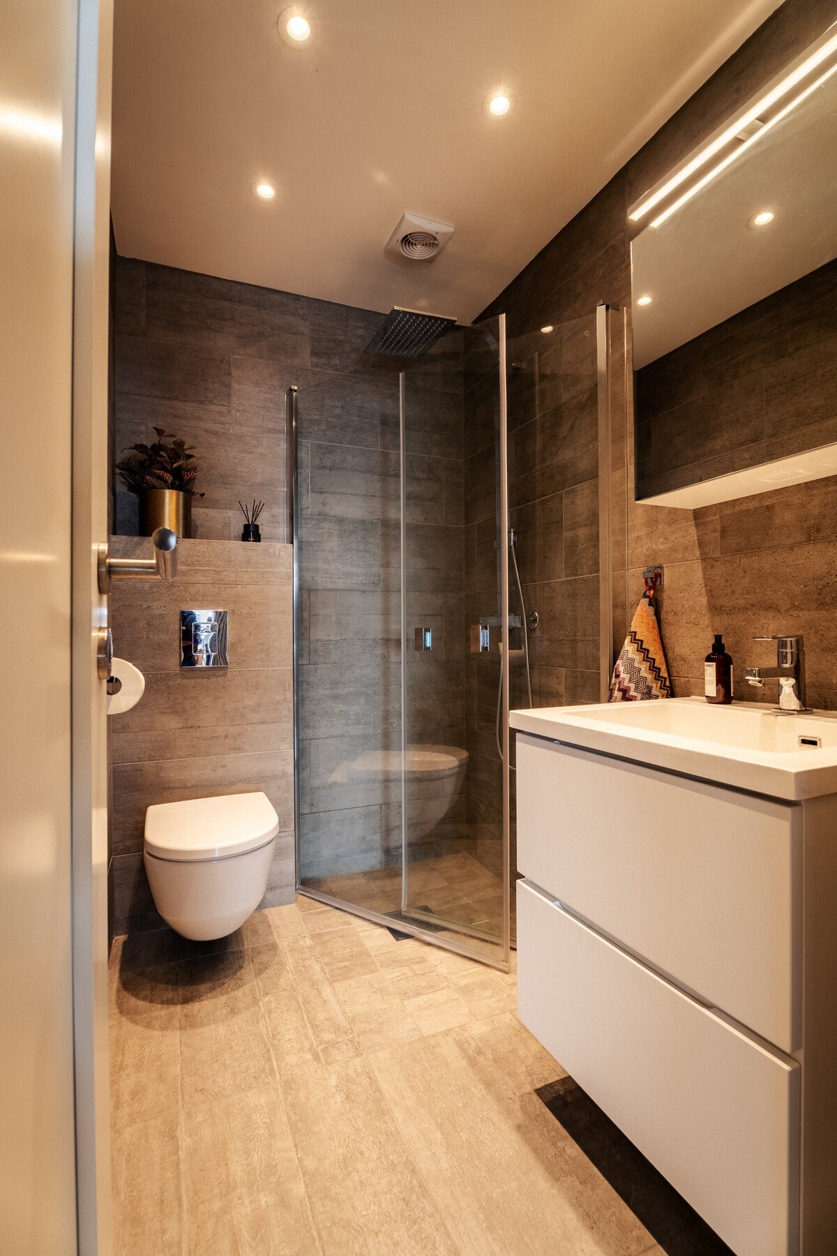 To bad i denne etasjen. Dette badet er totalrenovert - lekkert og moderne med store mørke fliser. Galleribilde