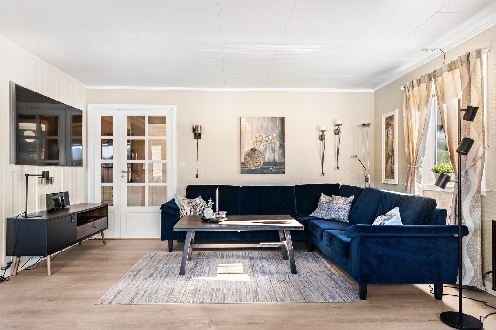 Lys stue med store vindusflater som slipper inn rikelig med naturlig lys. Galleribilde