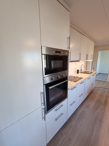 Kjøkkenet har god lagringsplass og tar hensyn til enkel bruk. Ekstra belysning under overskap og avtreksvifte med belysning gjør dette til et brukervennlig kjøkken for flere. Galleribilde