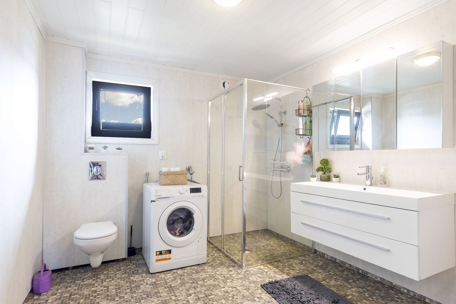 Bad i 2. etasje fra 20121/2022. Gulv med belegg. Vegger med våtromsplater, og himling med mdf panel. Innredning med slette fronter. Heldekkende servant og speilskap. Opplegg for vaskemaskin. Vegghengt toalett. Dusjhjørne med glassvegg. Galleribilde