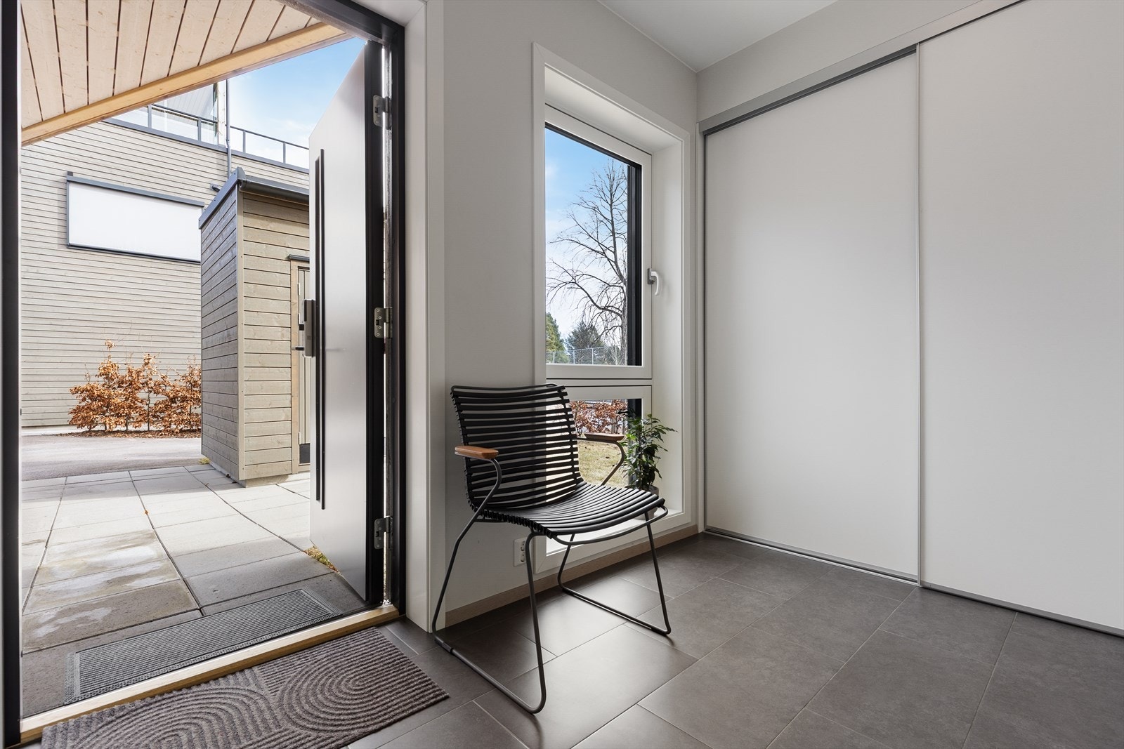Entreen har praktiske flis på gulv og skyvedørsgarderobe med oppbevaringsplass. Galleribilde