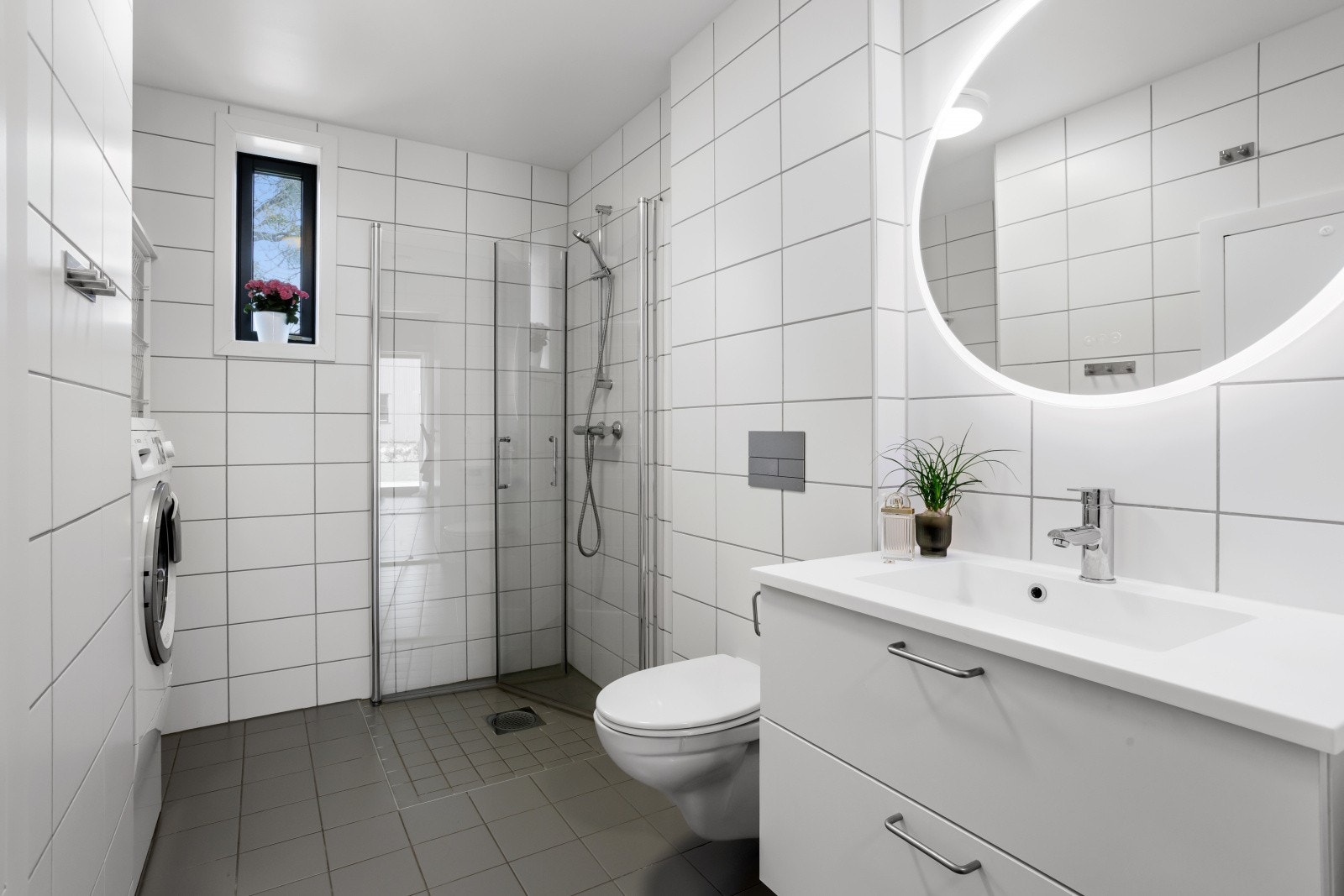 Hovedbadet i første etasje er fra 2022, med flislagt gulv med varme, dusjnisje og opplegg for vaskemaskin. Galleribilde