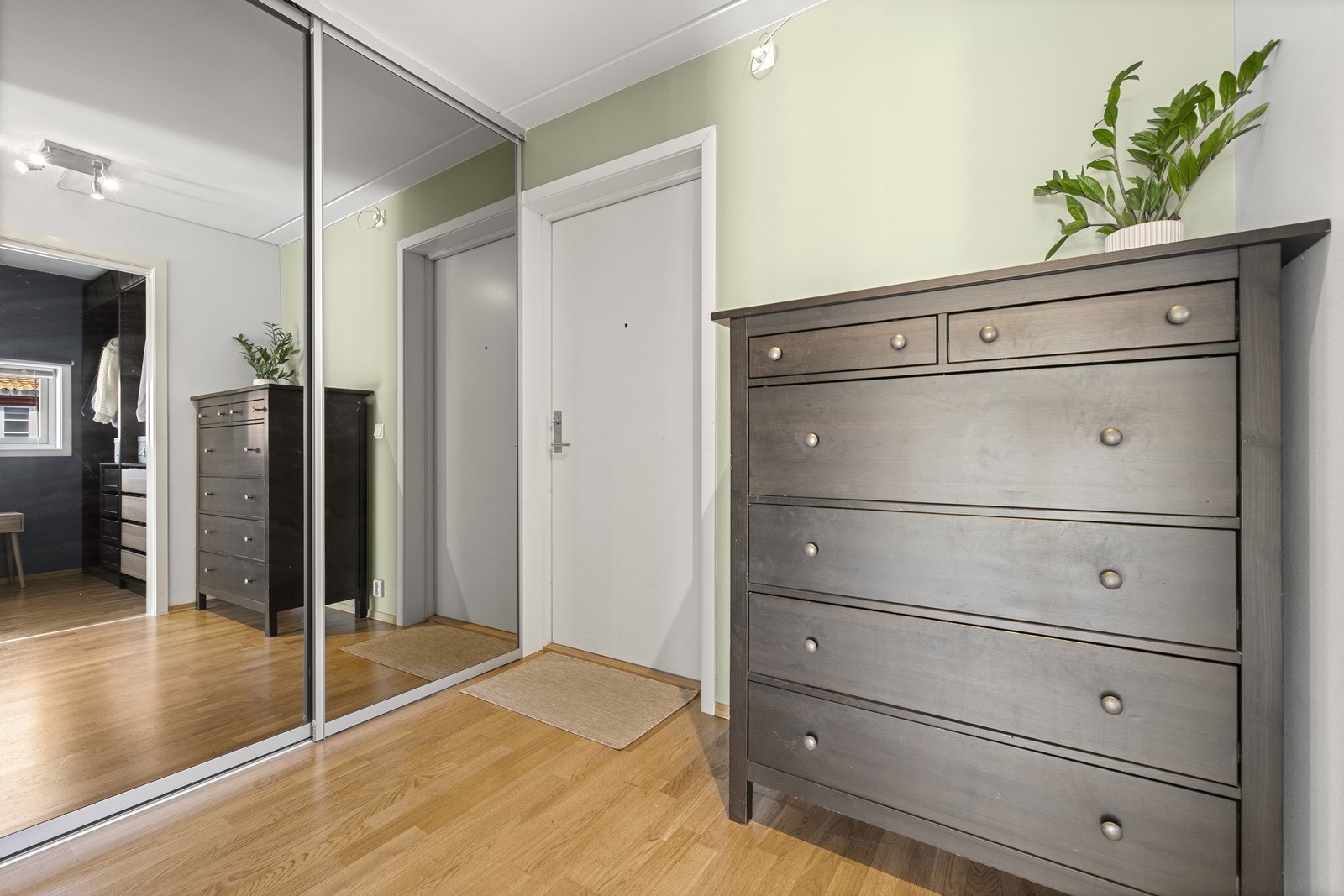 Entréen gir et godt førsteinntrykk og har rikelig med oppbevaringsplass i en stor skyvedørsgarderobe med speilfronter. Galleribilde