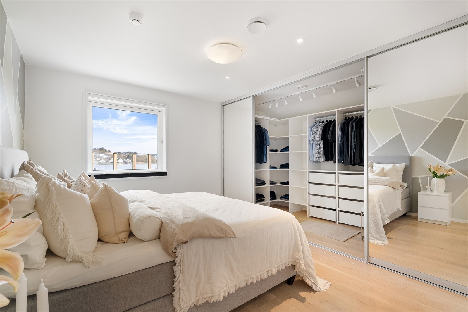 Gode oppbevaringsmuligheter i stort, praktisk walk-in closet med måltilpasset innredning fra HTH, skyvedører og god belysning. Her kan du nyte sjøutsikten fra sengekanten. Galleribilde