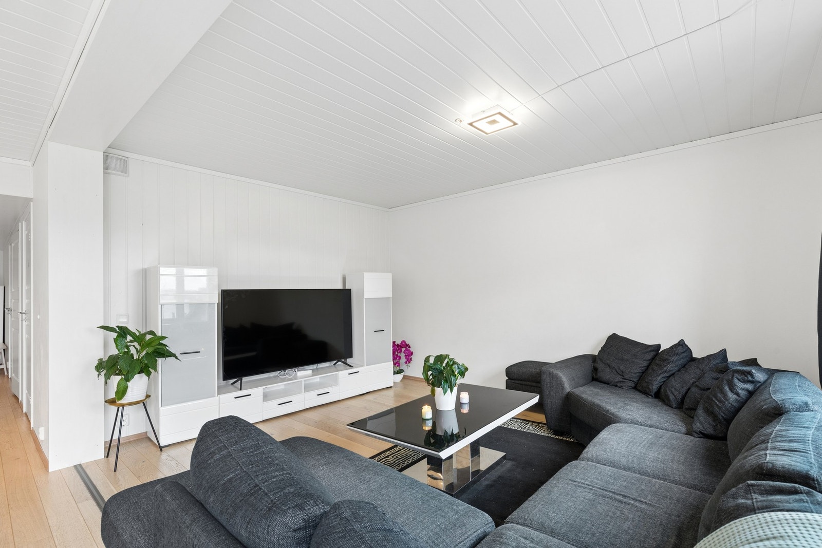 Rommet har god plass til en større sofagruppe og øvrig møblering, og oppleves som et naturlig samlingspunkt i boligen. Galleribilde