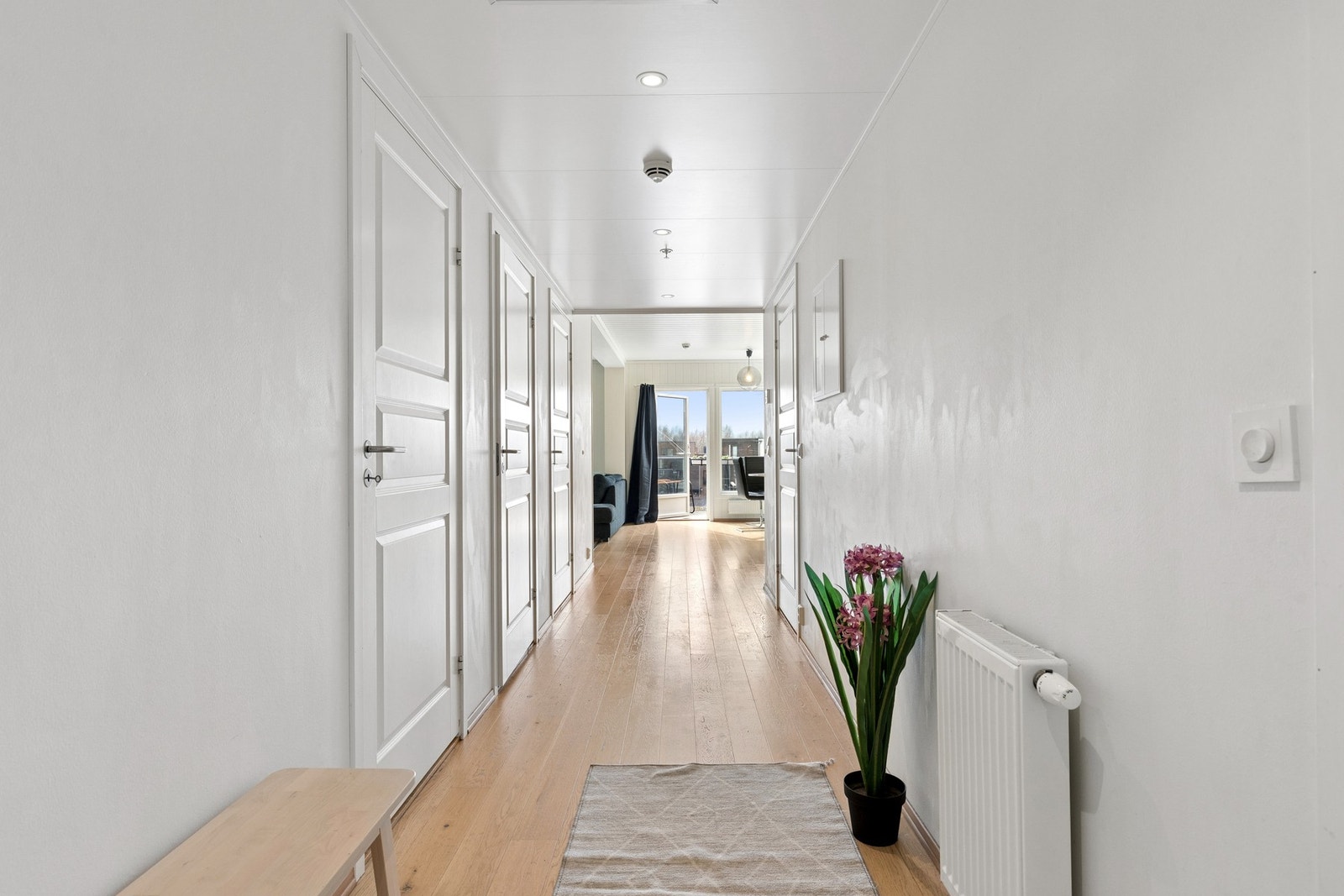 Leiligheten ønsker velkommen med en lys og romslig entré/gang med parkett på gulv og lyse overflater. Galleribilde