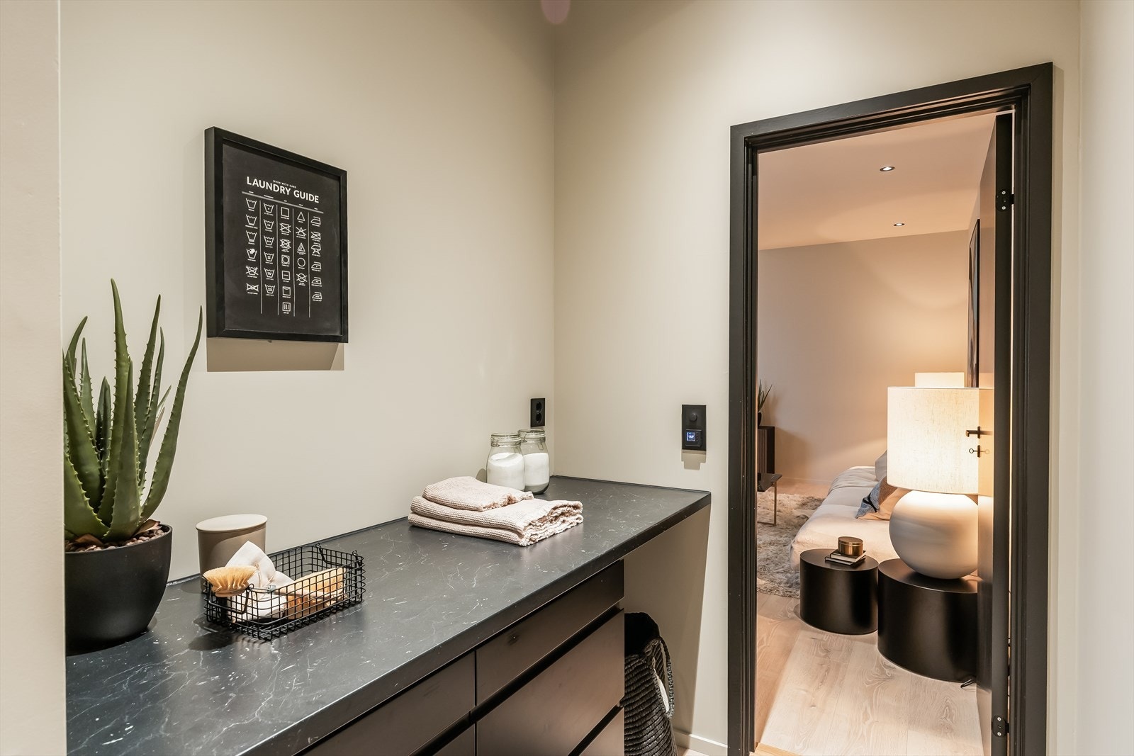 Vaskerommet har praktisk innredning fra Epoq, arbeidsbenk, opplegg for vaskemaskin, aquaalarm, varmefolie i gulv og sorte innfelte downlights. Galleribilde