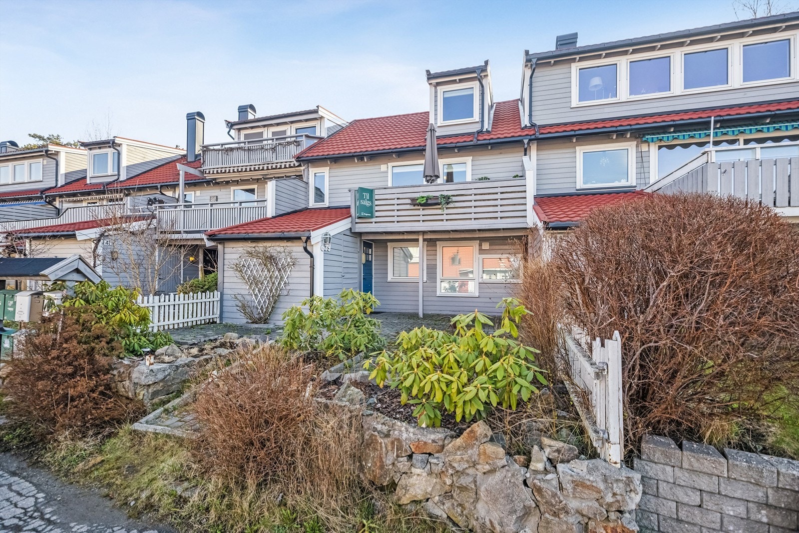 Disp. tomt er pent opparbeidet med belegningsstein, div. beplantninger, overbygget platting ved inngangsparti samt stor usjenert terrasse/hage og balkong. Galleribilde