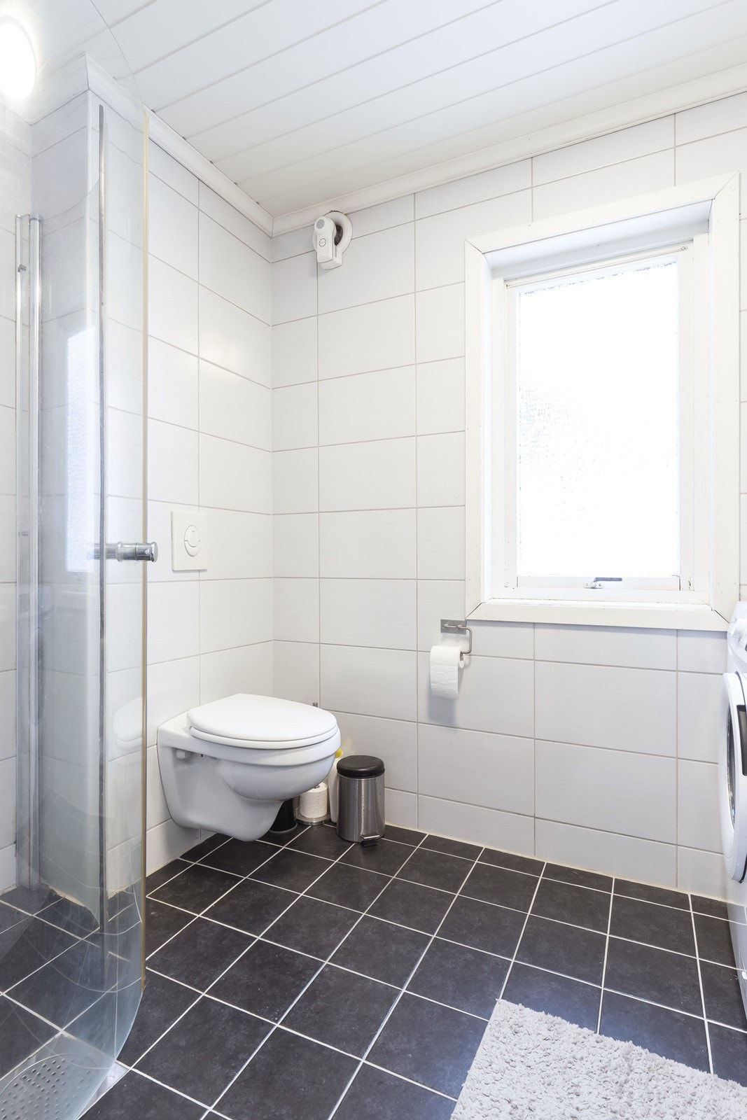 Badet i 1.etasje er flislagt og inneholder dusjhjørne og vegghengt toalett. Galleribilde