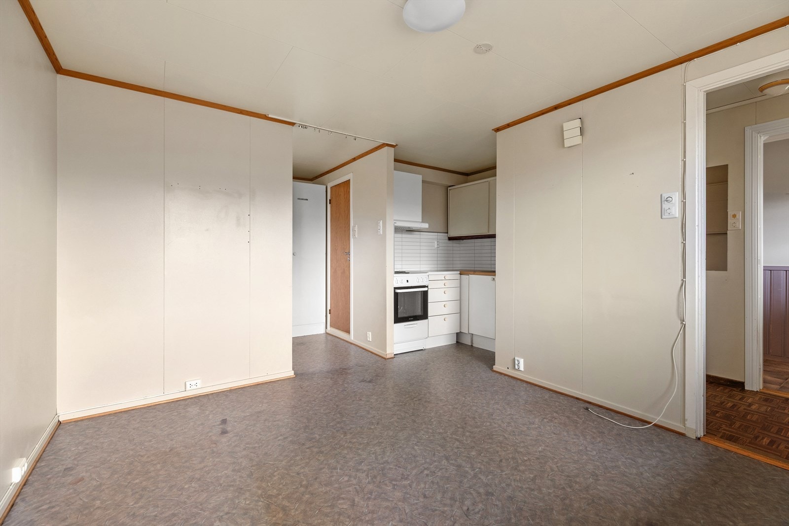 Kjøkkenkrok i kjeller med laminat på gulv og slettmalte vegger. Innredning med glatte fronter og laminat benkeplate med nedfelt oppvaskkum. Frittstående komfyr. Ventilator med kullfilter. Galleribilde