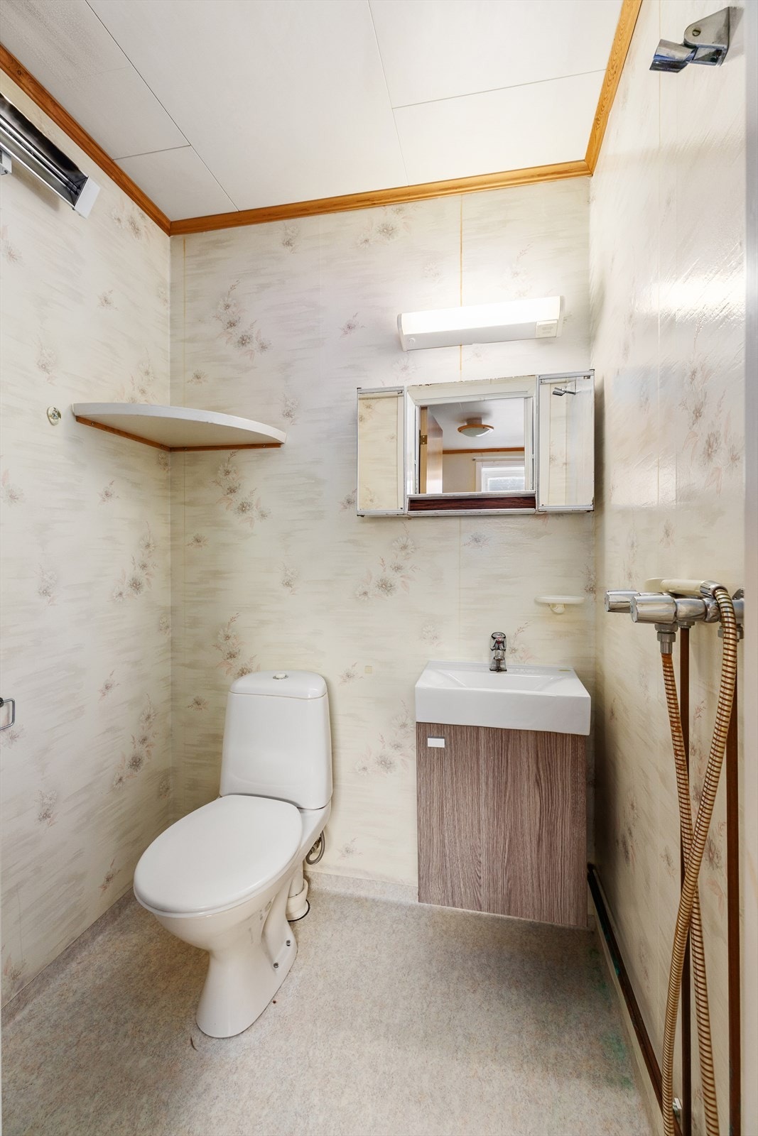 Bad i kjeller med belegg på gulv og våtromstapet på vegger. Rommet er innredet med dusjløsning, wc og servant med tilhørende innredning. Naturlig ventilasjon. Galleribilde