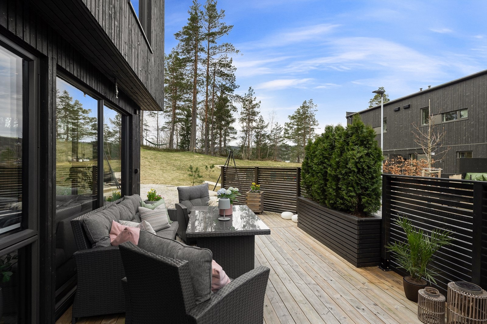 Skillevegger og blomsterkasser i tre skaper en lun og skjermet uteplass. Galleribilde