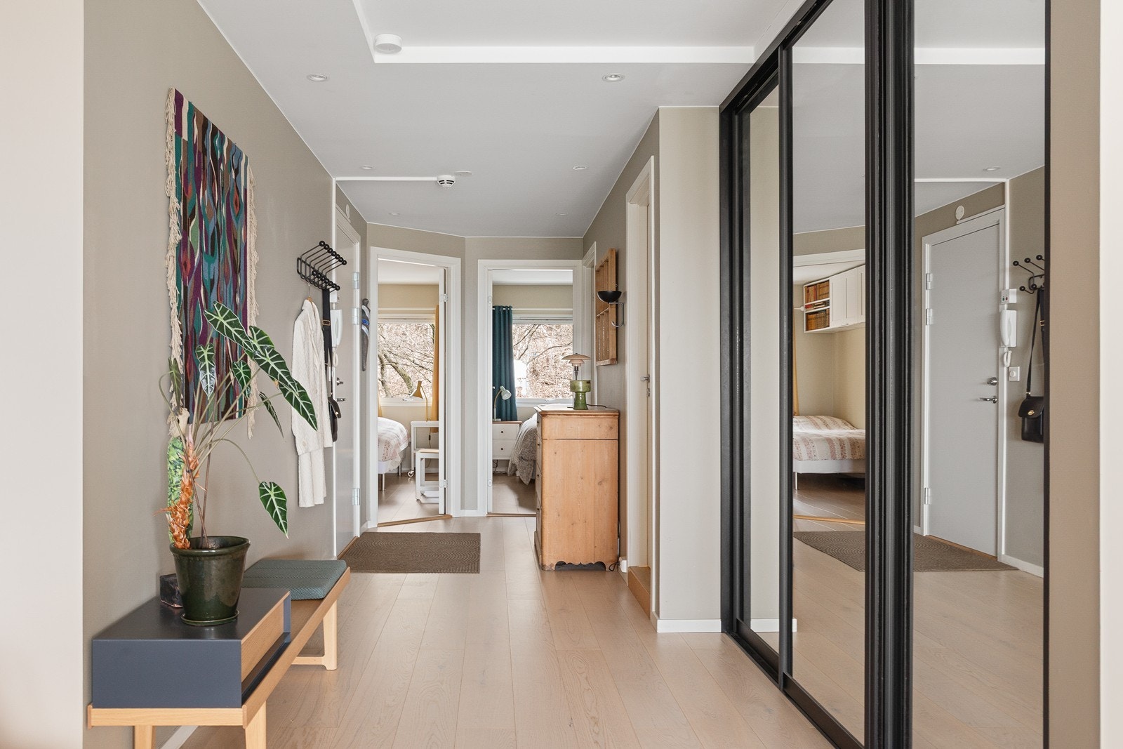 Entré med rikelig oppbevaringsplass i skyvedørsgarderobe Galleribilde