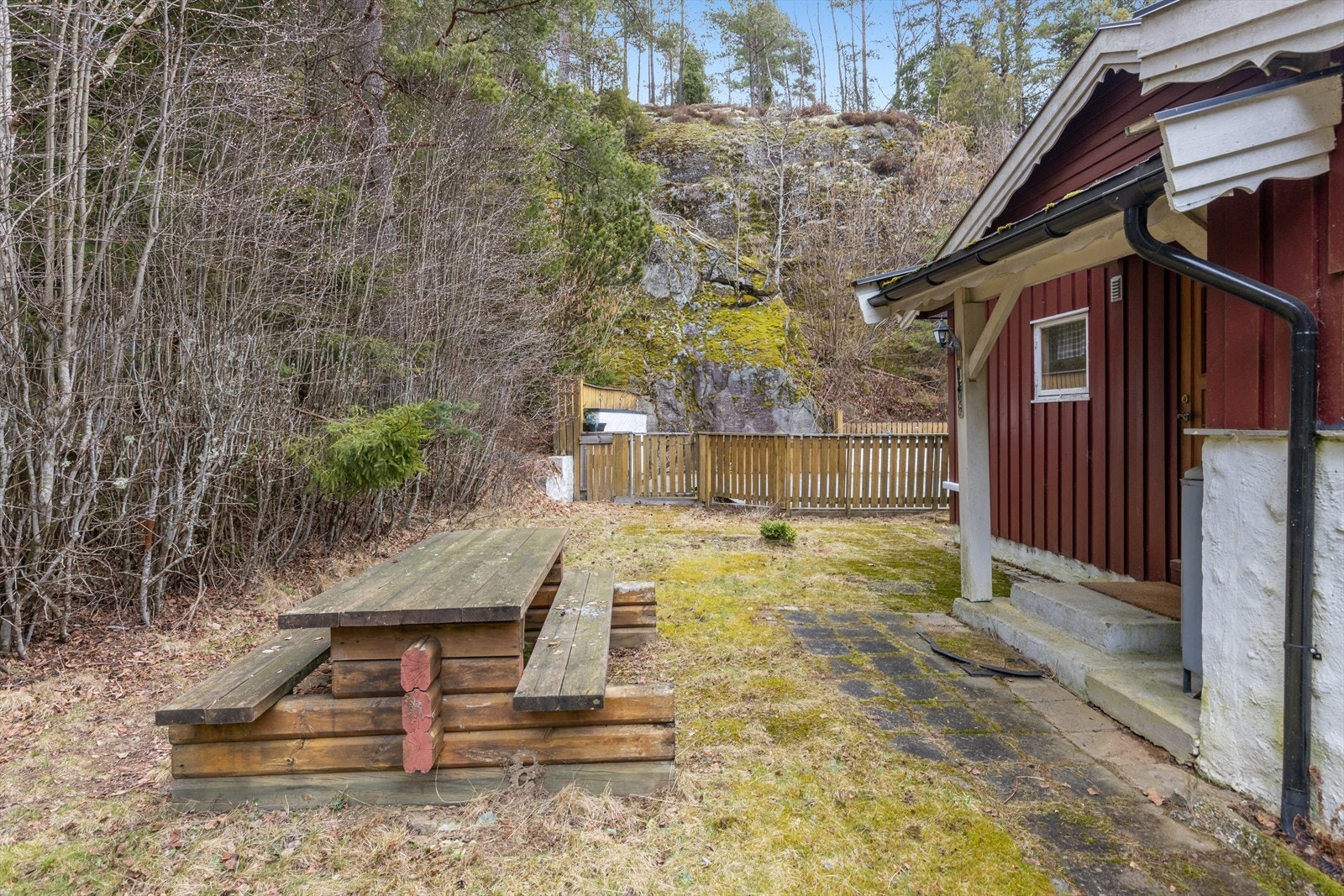 Tomten er opparbeidet med hage og ligger i et skrånende terreng. Galleribilde