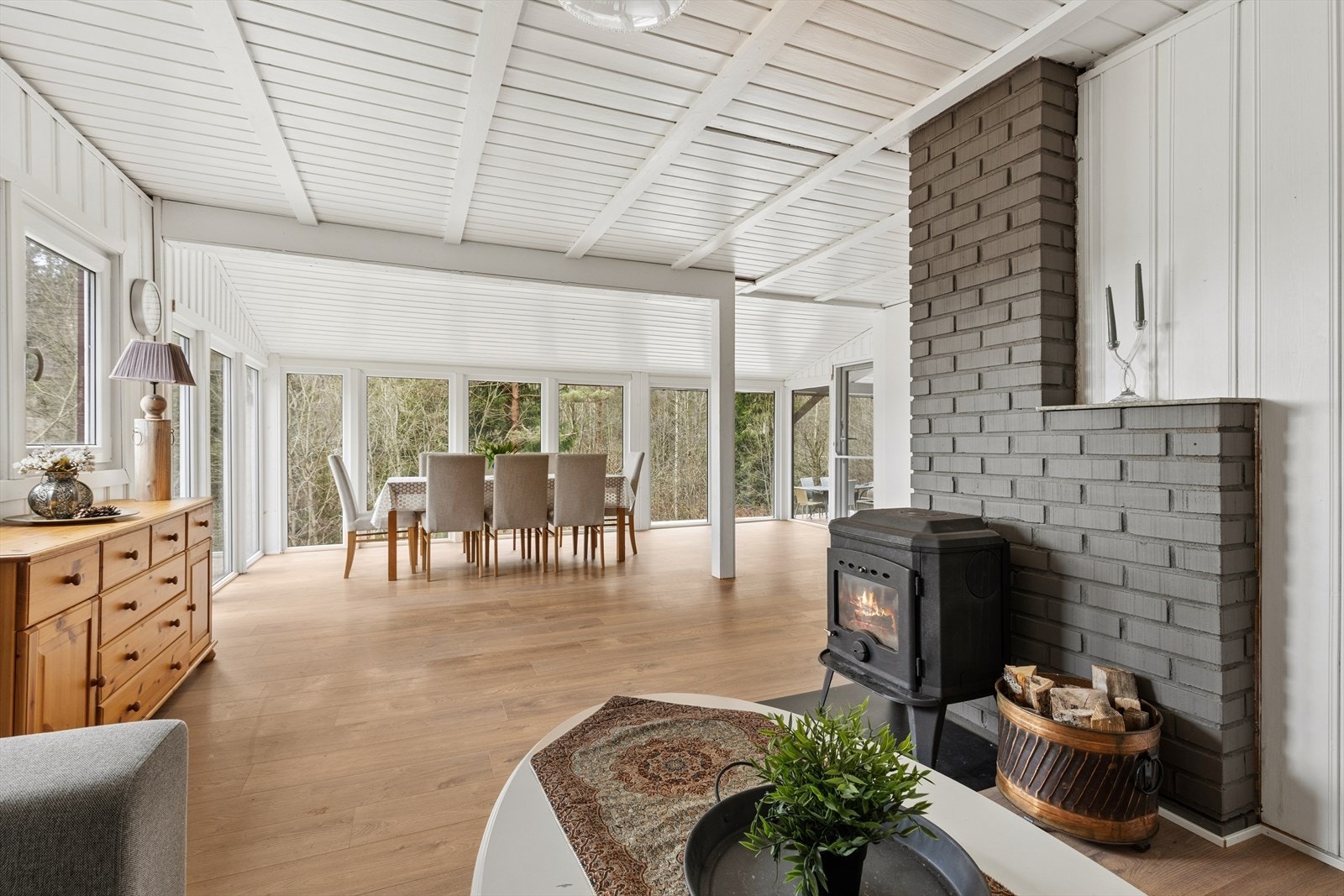 Den åpne stue- og kjøkkenløsningen skaper en sosial og luftig atmosfære. Vedovnen gir både varme og hygge. Galleribilde