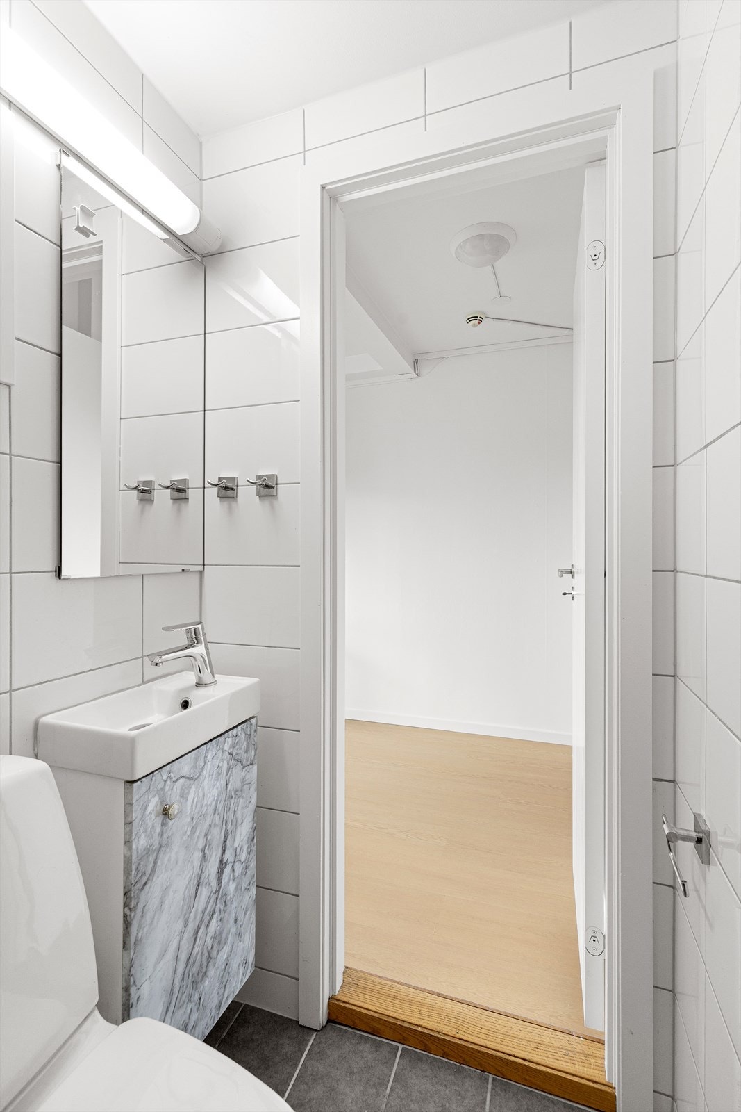 Badet er innredet med WC, dusjplass med vegger og servant med ettgreps blandebatteri i innredning. Galleribilde