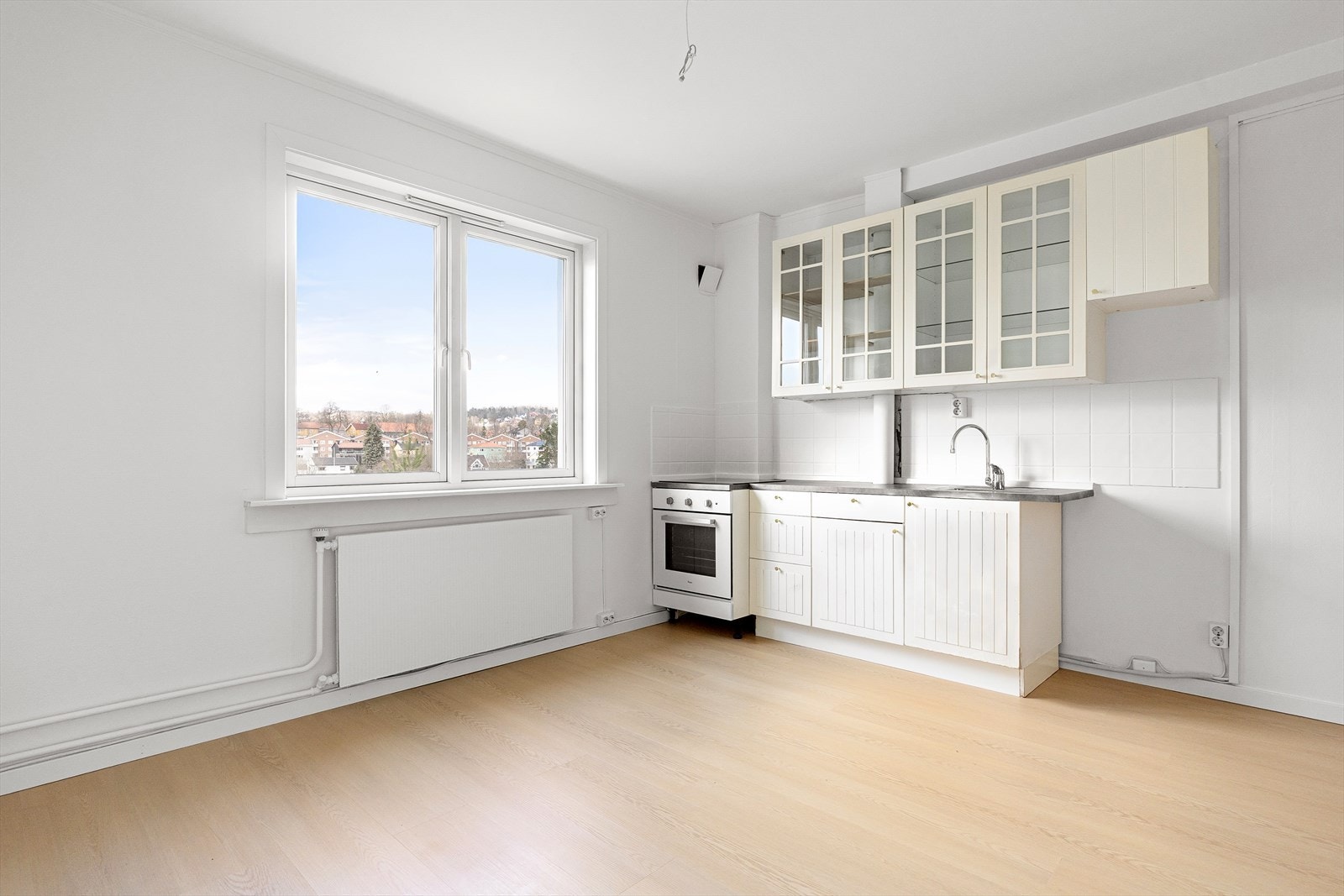 Innredningen har hvite, profilerte fronter, hvorav fire overskap med glassfelt, samt fliser mellom overskap og laminat benkeplate. Galleribilde