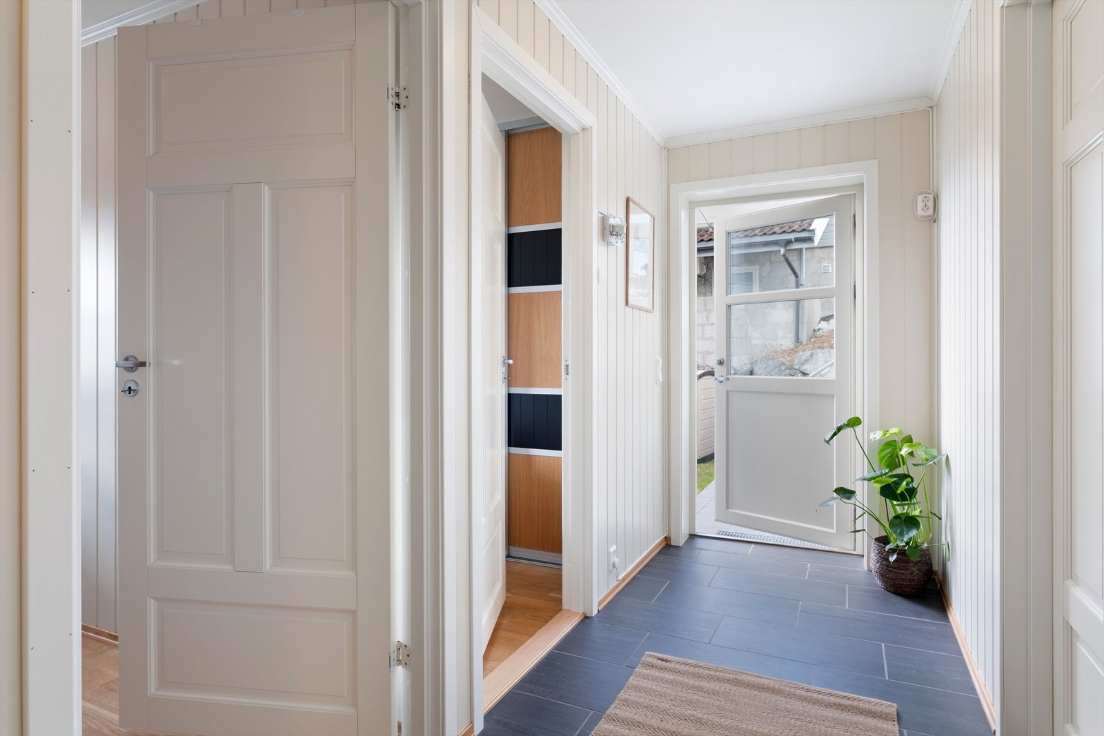Gang i underetasje med tilkomst ut til hage og terrasse. Galleribilde