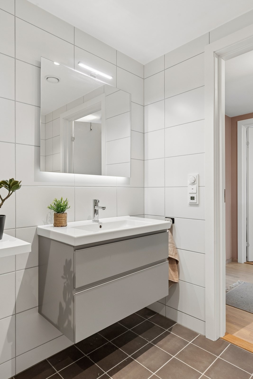 Innredningen består av stilrene, grå skapfronter med romslige skuffer og god oppbevaringsplass, samt speil med integrert belysning. Galleribilde