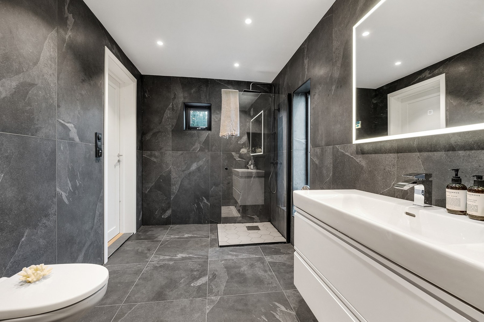 Badet har varmekabler i gulv og opplegg for både vaskemaskin og tørketrommel. Galleribilde