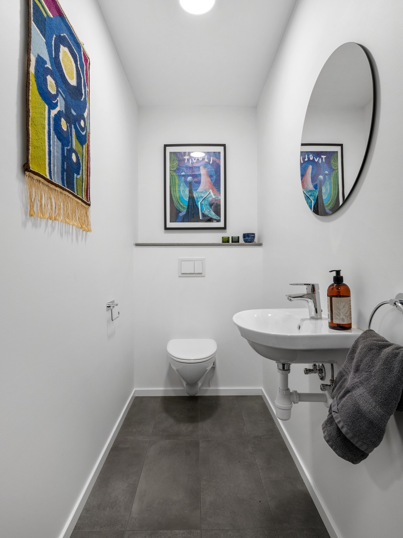 Wc-rommet ligger i praktisk tilknytning til gangen i første etasje og er innredet med veggmontert toalett, servant på skapseksjon og speil. Galleribilde