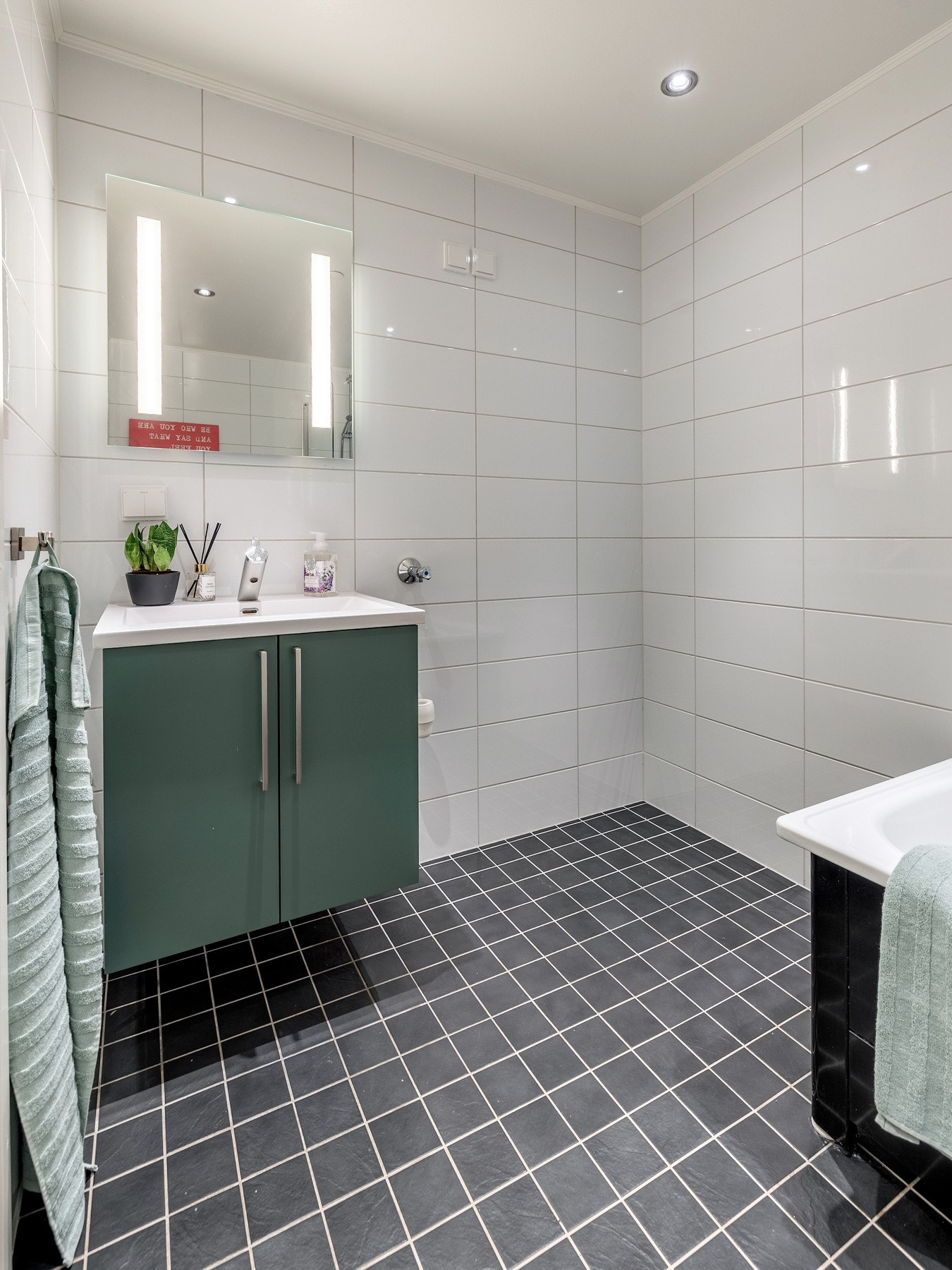 Badet har et stilrent uttrykk med flislagte vegger- og gulv, varmekabler og innfelt downlights. Galleribilde