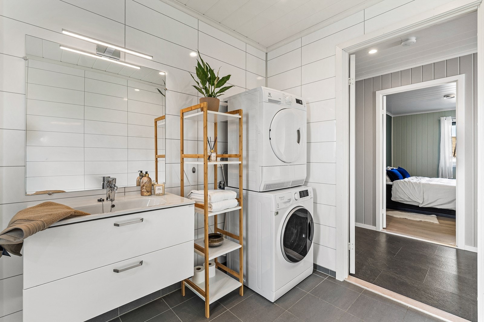 Lyst og moderne bad med fliser på gulv og baderomsplater på vegg Galleribilde