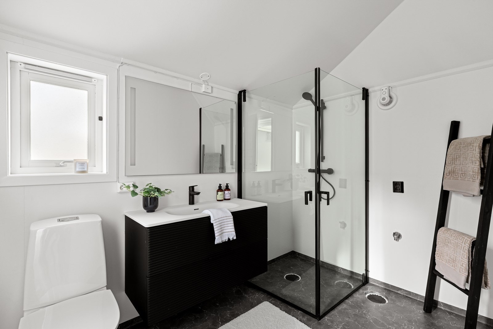 Badet er moderne innredet med varmekabler i gulvet, og inneholder toalett, servant, dusjhjørne samt opplegg for vaskemaskin. Galleribilde