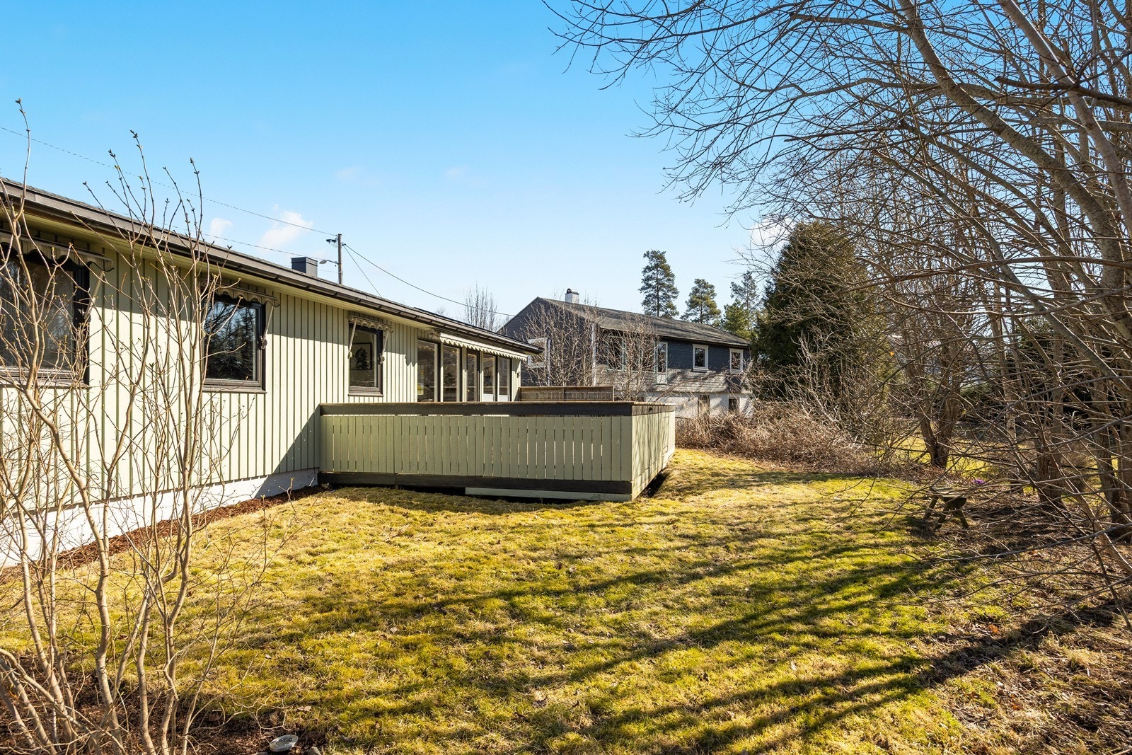 Tomten er solrik og barnevennlig og er opparbeidet med gruset gårdsplass og hage med plen og beplantning Galleribilde