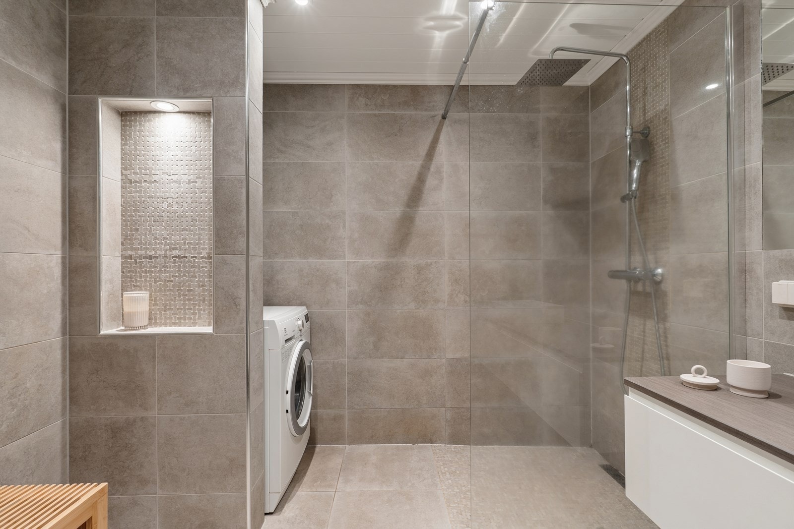Badet er utstyrt med dusjhjørne med regndusj og hånddusj samt opplegg for vaskemaskin. Galleribilde