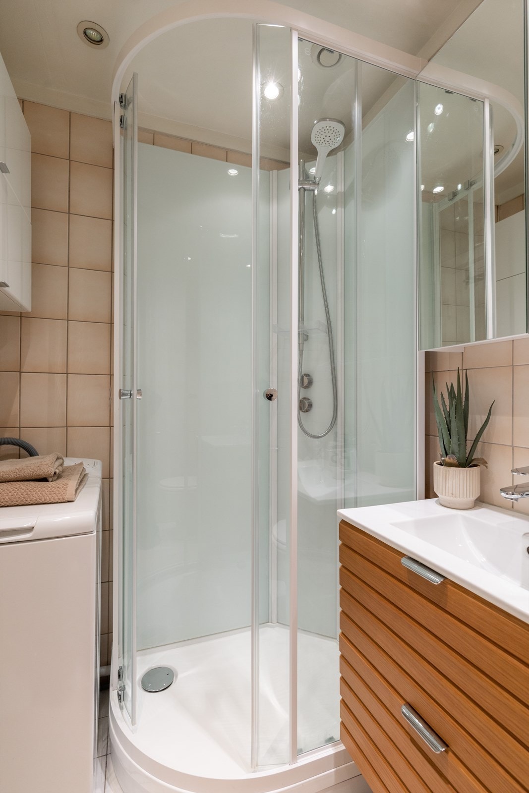 Badet er innredet med klosett, servant nedfelt i innredning, speilskap og dusjkabinett. Galleribilde