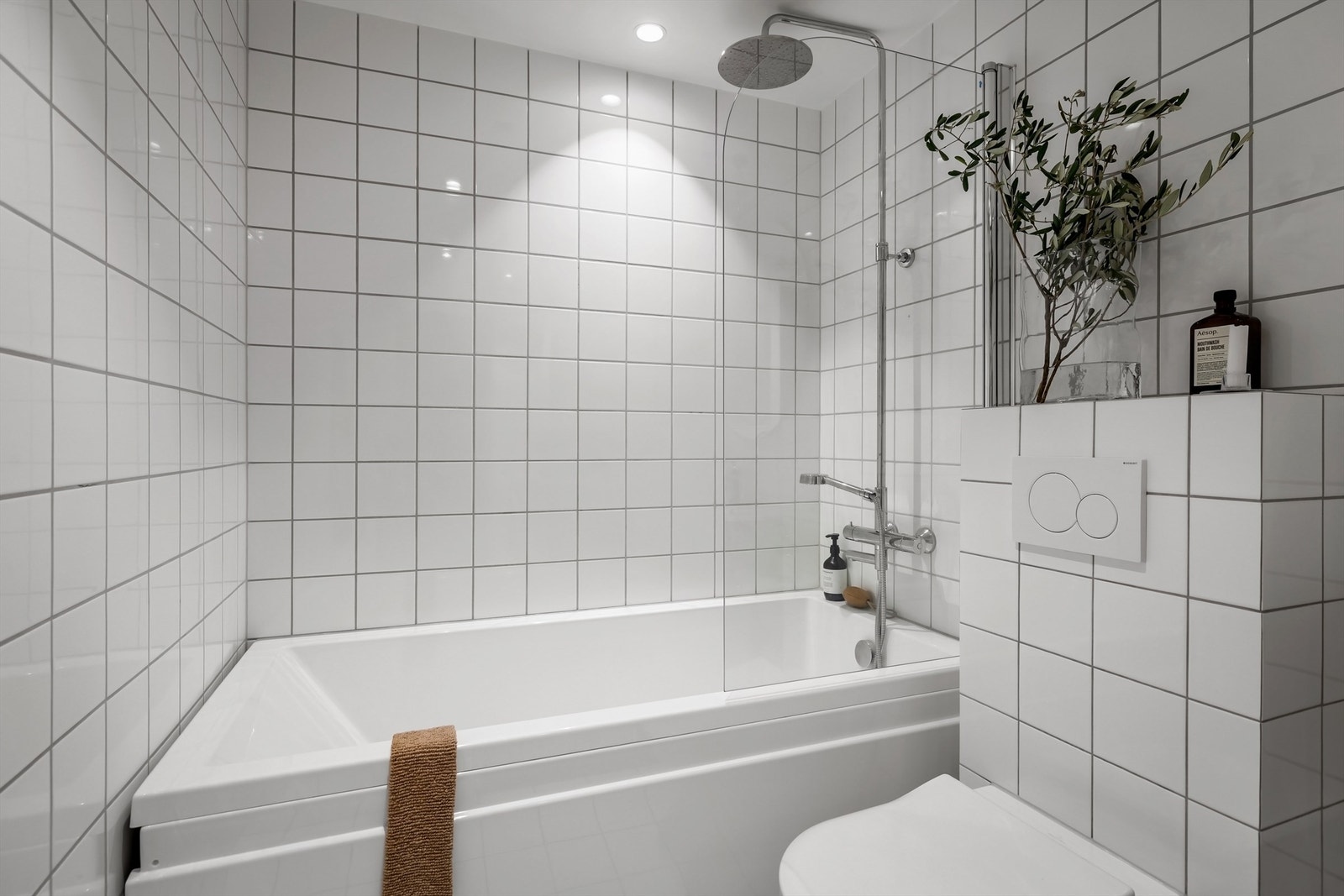 Baderommet er innredet med et dypt badekar med glassvegg og dusjsett med rainshower Galleribilde