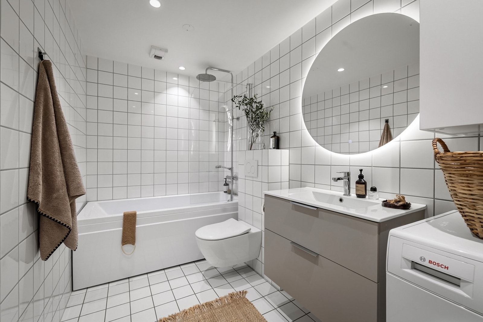 Flislagt baderom med gulvvarme, downlights i himling og opplegg for vaskemaskin Galleribilde