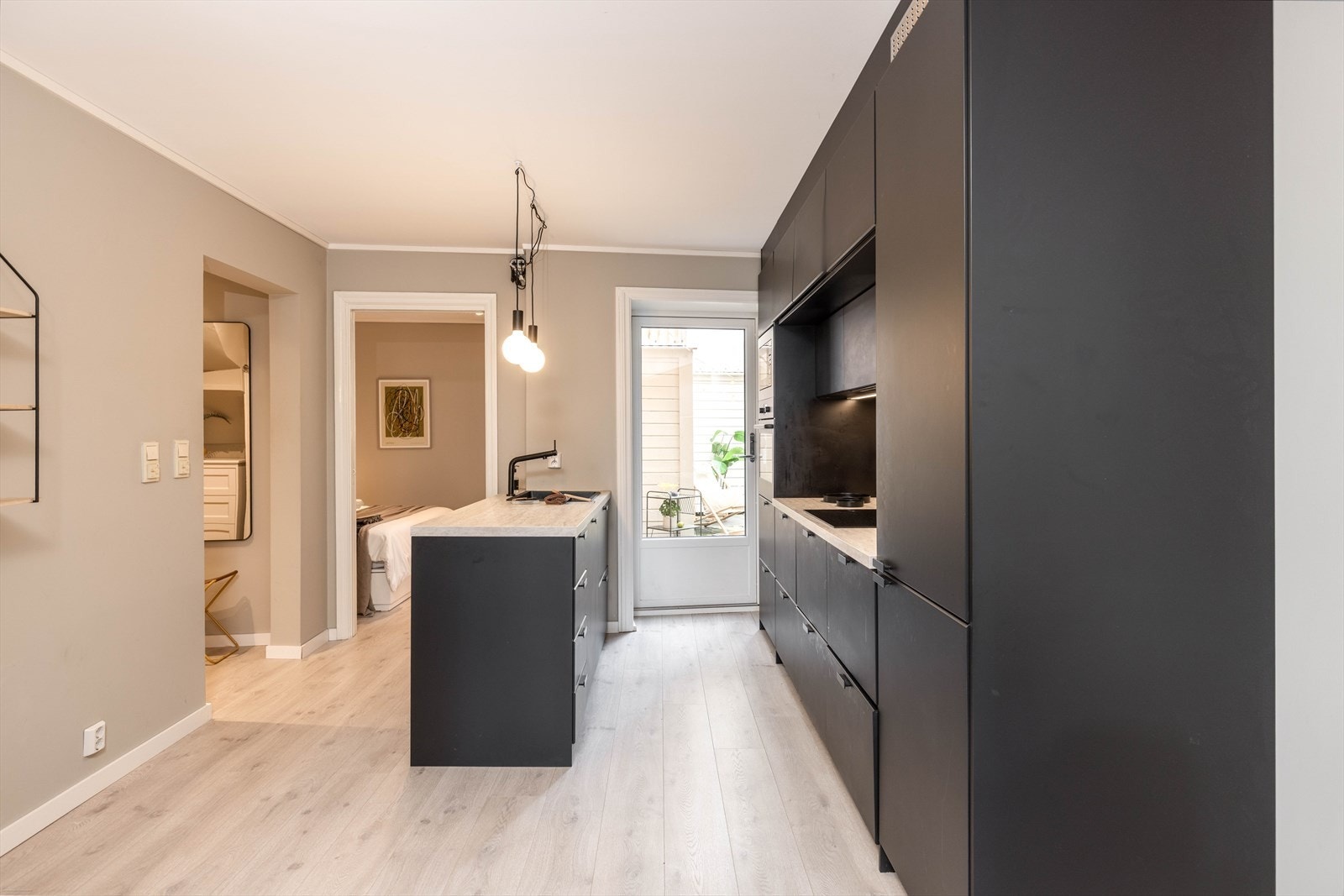 Kjøkkenet fra 2021 har utgang til rolig bakgård via terrassedør. Galleribilde