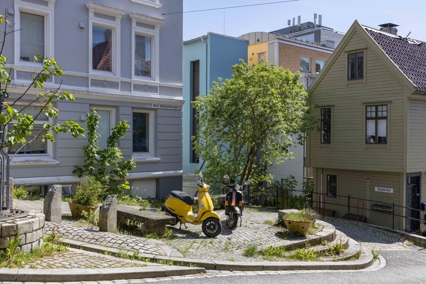Pent opparbeidet gatetun med beplantning, sykkelparkering og klassiske fasader. Galleribilde