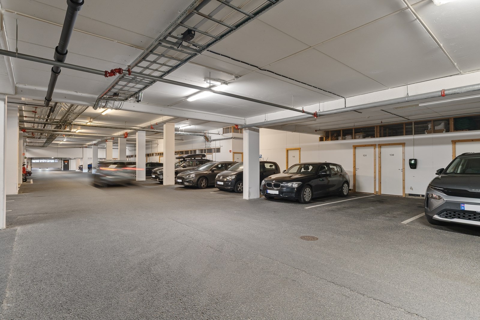 En fast parkeringsplass med elbil-lader. Praktisk bod i bakkant av parkeringsplassen Galleribilde