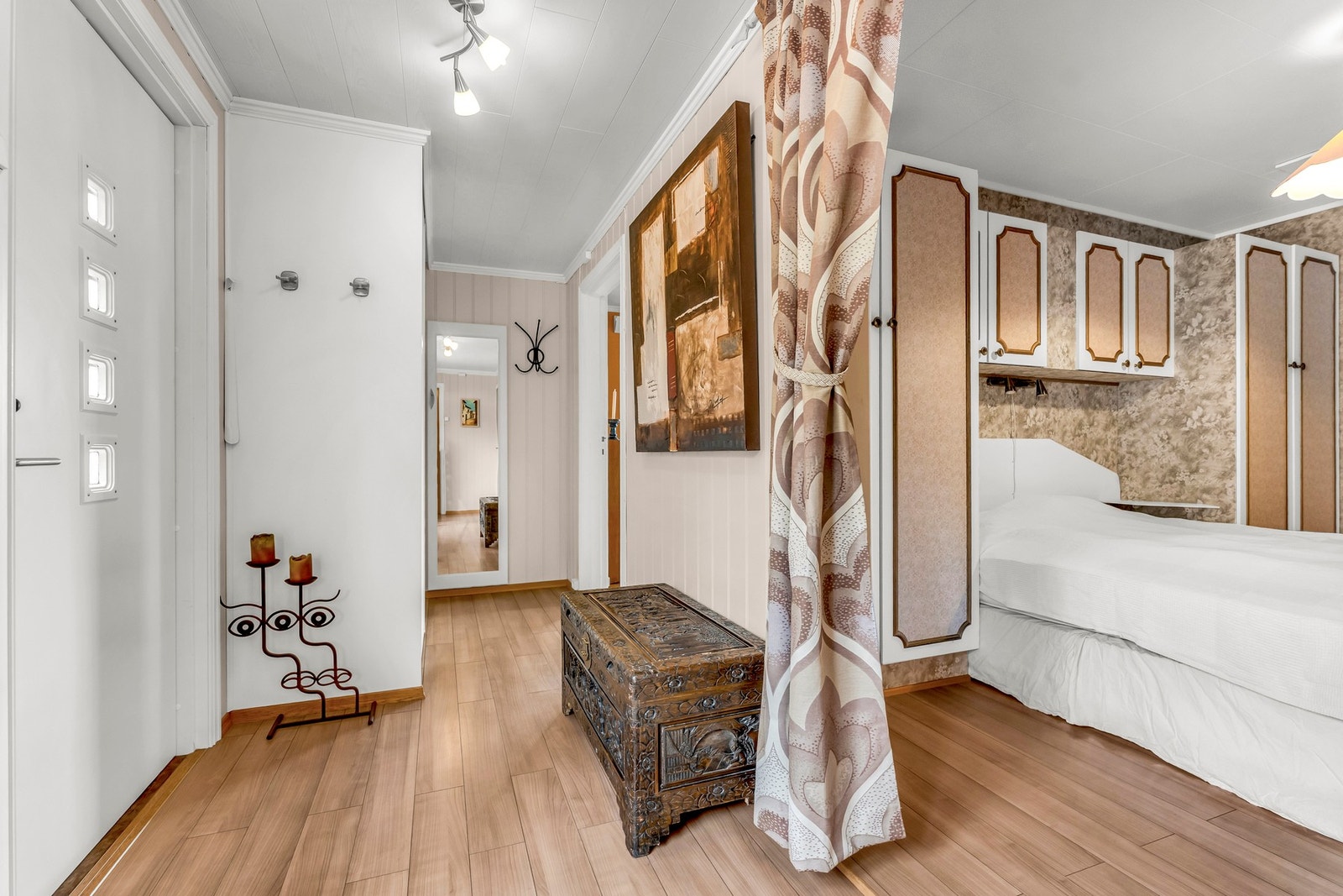 Lyst rom med parkettgulv og panelvegger, innredet med garderobeskap og belysning i taket. Galleribilde