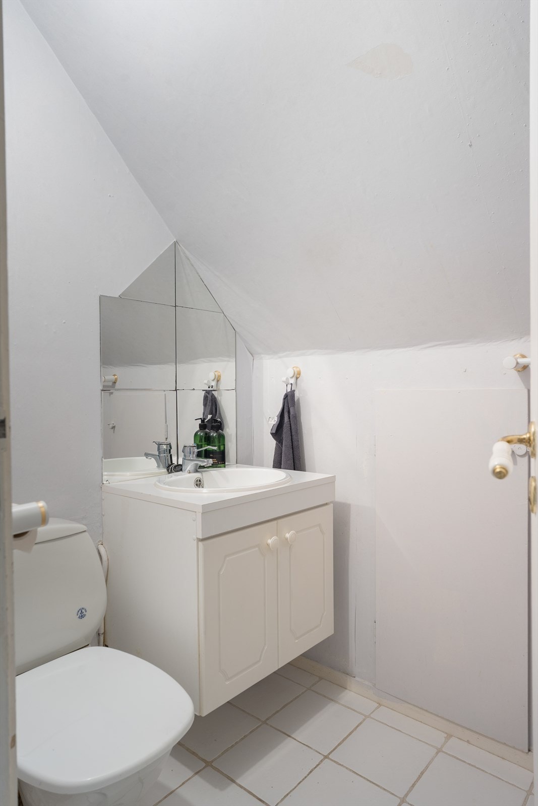 WC på loftet med fliser på gulv, tapet på vegger og malte slette plater i himling Galleribilde