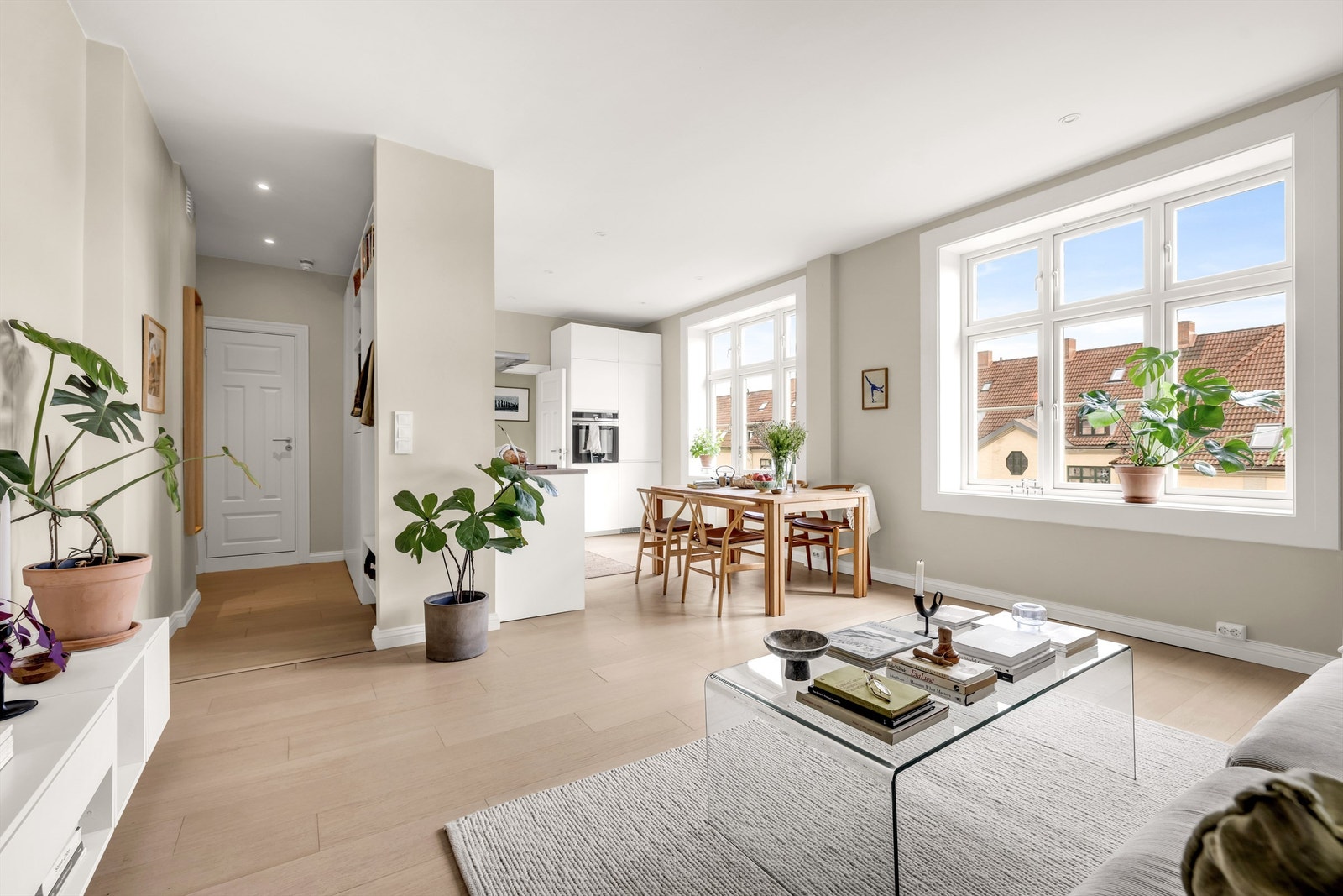 Åpen stue- og kjøkkenløsning med store vindusflater som sørger for rikelig med naturlig lys inn i leiligheten. Foto: Bjørnar Solberg. Galleribilde