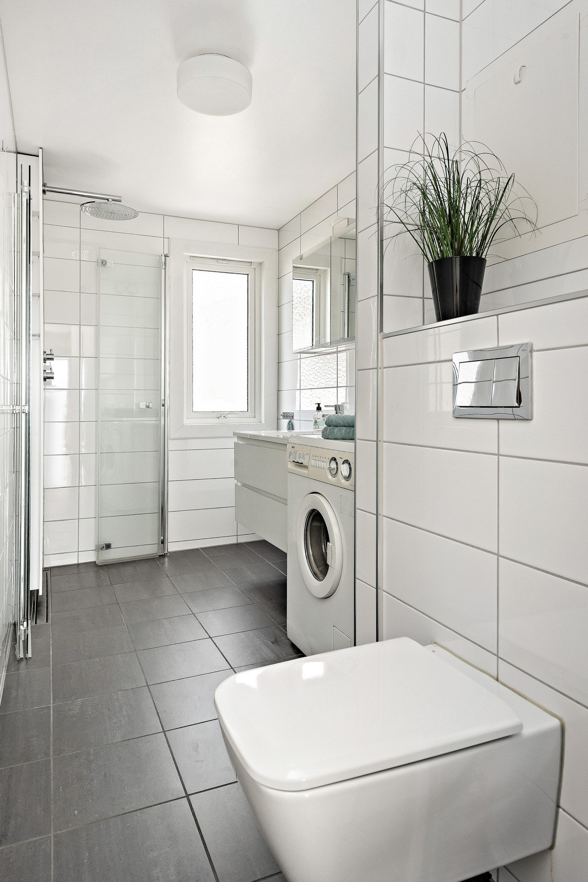Badet er innredet med baderomsinnredning fra Aspen, vegghengt skap med speilfronter, vegghendt toallet og vaskemaskin - Vaskemaskin følger handelen Galleribilde
