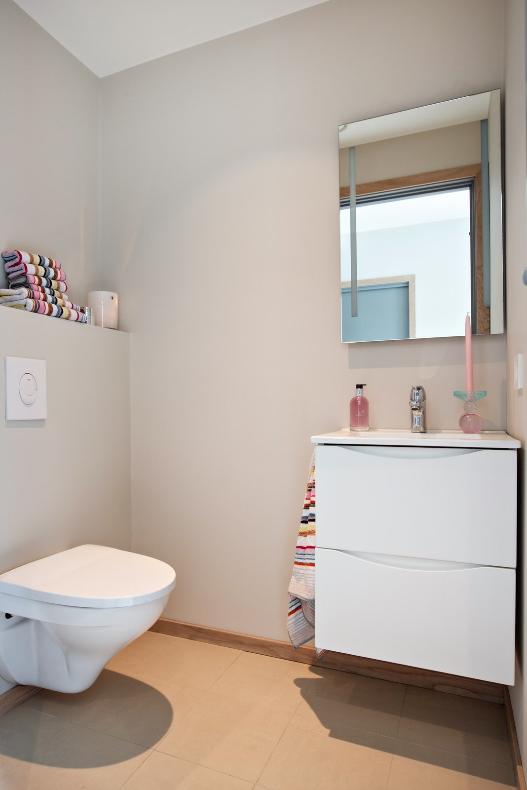 I tillegg til hovedbadet har boligen et separat toalettrom. Rommet er innredet med veggmontert toalett og moderne servantløsning med underskap og speil. Lyse, nøytrale farger og flislagt gulv. Galleribilde