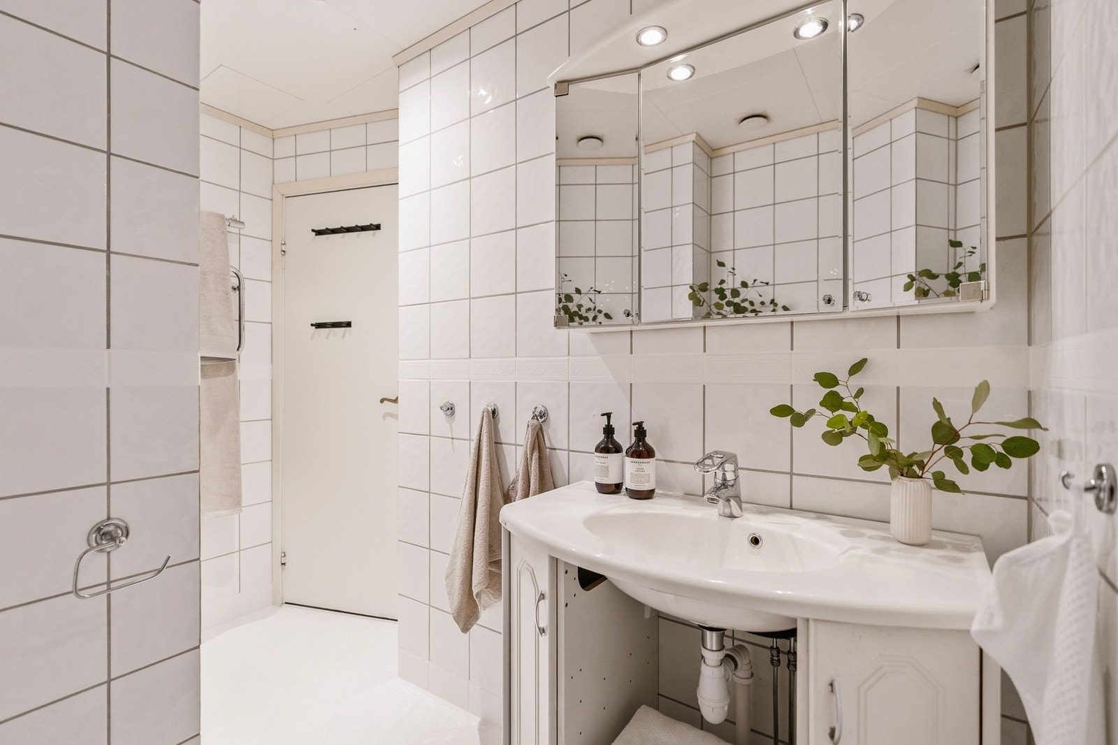 Praktisk utformet baderom fra ca. år 2002. Badet består av vegghengt toalett, servant med underskap, dusjhjørne samt opplegg for vaskemaskin. Galleribilde
