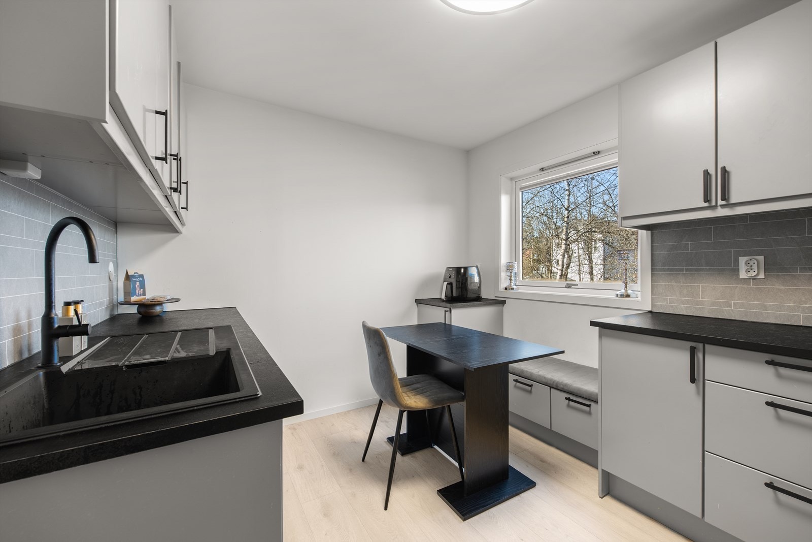 Kjøkkenet har innredning med glatte fronter og benkeplate i laminat. Her er det også plass til en hyggelig spiseplass ved vinduet. Galleribilde
