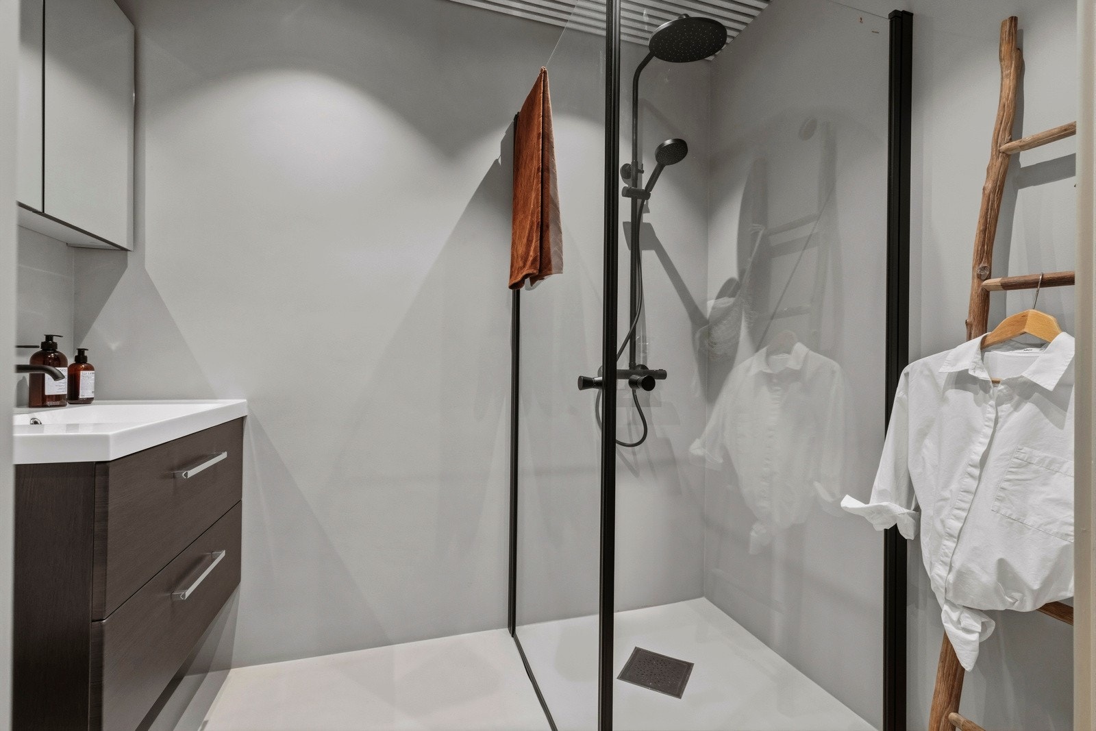 Badet har opplegg for vaskemaskin, toalett, dusjdører i herdet glass, speilskap, baderomsinnredning med finerte fronter og heldekkende servant. Galleribilde
