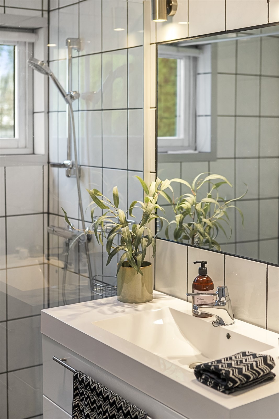 Baderomsinnredning med servant og speil med belysning. Galleribilde