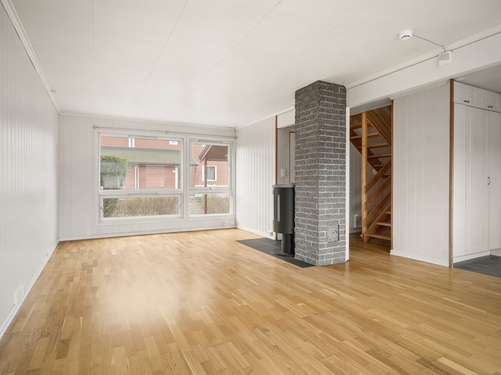 Stuen er romslig og har en sentralt plassert mursteinspipe med vedovn. Galleribilde