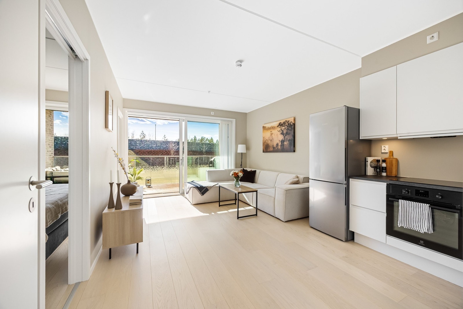 Store vindusflater slipper inn mye naturlig lys og skaper en luftig atmosfære i boligens oppholdssone Galleribilde